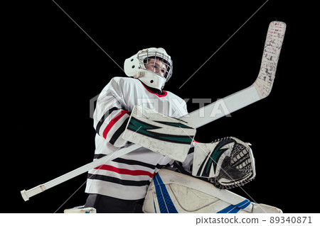 Portrait of teen boy, hockey player, goalkeeper training isolated over black studio background. Dynamic sport Portrait of teen boy, hockey player, goalkeeper training isolated over black studio background. Dynamic sport 89340871