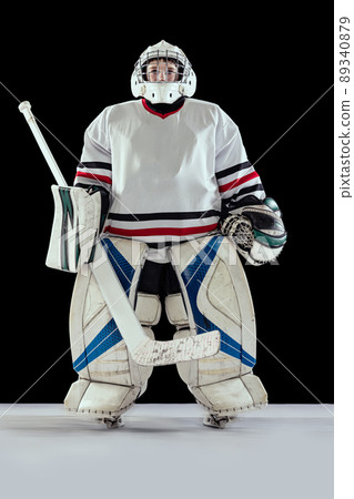 Full-length portrait of boy, child, hockey player in special uniform of goalkeeper posing isolated over black studio background 89340879