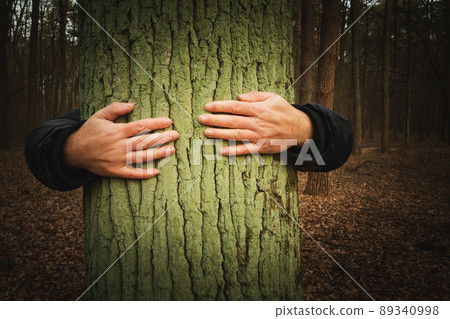 Man embracing a tree in the forest 89340998