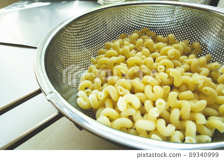 Fresh pasta in a stainless steel strainer 89340999