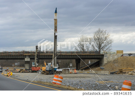 Construction of new road in a excavator digs and moving the ground Construction of new road in a excavator digs and moving the ground 89341635
