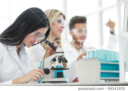 female scientist uses a microscope for research in a laboratory 89341850