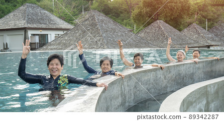 Healthy Asian elderly, aging senior old friends exercising in swimming pool having fun, enjoying summer vacation, holiday relaxation for ageing society well-being and elder health care concept Healthy Asian elderly, aging senior old friends exercising in swimming pool having fun, enjoying summer vacation, holiday relaxation for ageing society well-being and elder health care concept 89342287