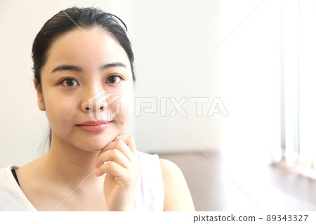 The face of a woman touching his cheek The face of a woman touching his cheek 89343327
