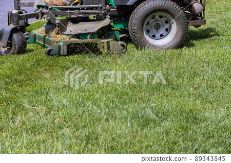 Machine for cutting lawns mover on green grass in garden 89343845