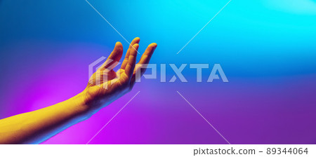Studio shot of aethentic human hand isolated on gradient purple-blue background in neon light. Concept of human relation, community, togetherness Studio shot of aethentic human hand isolated on gradient purple-blue background in neon light. Concept of human relation, community, togetherness 89344064