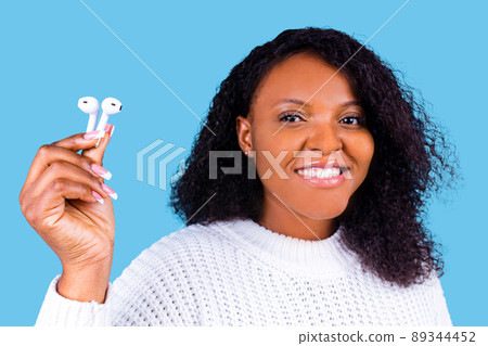 african american woman isolated on blue background in studio Listen music with earpods 89344452