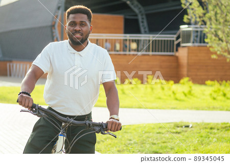 ecology and transportation concept. modern young Afro American businessman cycling to work on bicycle ecology and transportation concept. modern young Afro American businessman cycling to work on bicycle 89345045