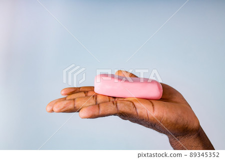 African man holds and show a piece of wet soap in studio white background African man holds and show a piece of wet soap in studio white background 89345352