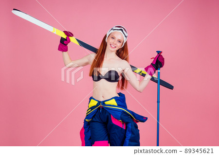 Attractive smiling young redhaired ginger woman skier in sunglasses, bikini and flower posing with skis on copy space pink background, mountains ski lift.medical insurance Attractive smiling young redhaired ginger woman skier in sunglasses, bikini and flower posing with skis on copy space pink background, mountains ski lift.medical insurance 89345621