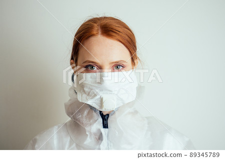 virologist woman in chemical protection mask ,glasses and gloves holding potential vaccine at the lab 89345789