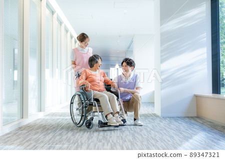 Young male and female caregivers and senior women in wheelchairs shooting cooperation "LINK FOREST" 89347321