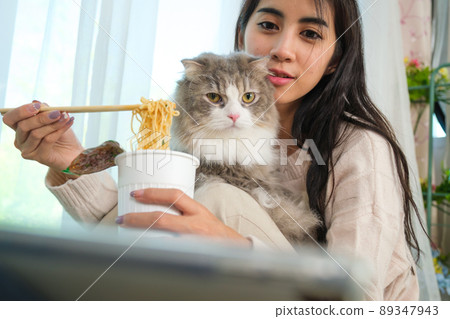Young Asian woman working from home with her cat 89347943