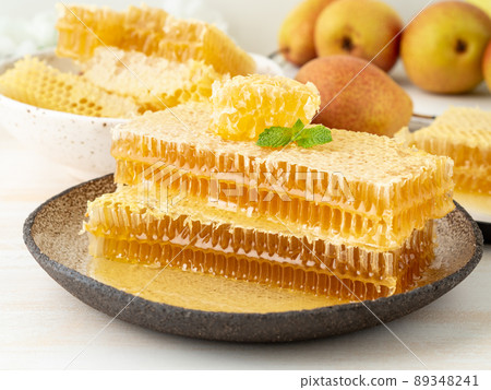 honey in honeycomb, close-up, on brown ceramic plate, on wooden rustic table, side view honey in honeycomb, close-up, on brown ceramic plate, on wooden rustic table, side view 89348241