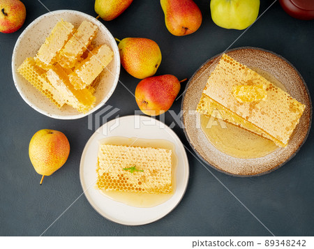 honey in honeycomb, close-up, on white ceramic plate, on wooden rustic table, side view, sunlight honey in honeycomb, close-up, on white ceramic plate, on wooden rustic table, side view, sunlight 89348242