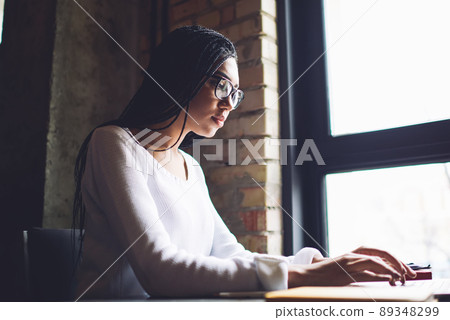 Concentrated black student working on project in loft workspace Concentrated black student working on project in loft workspace 89348299