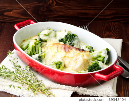 Chicken fillet baked with broccoli in bechamel sauce on dark wooden table. Healthy food 89348404
