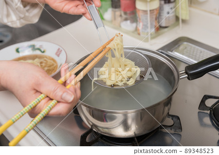 [Middle housewife boil ramen noodles with chopsticks and bamboo basket] 89348523