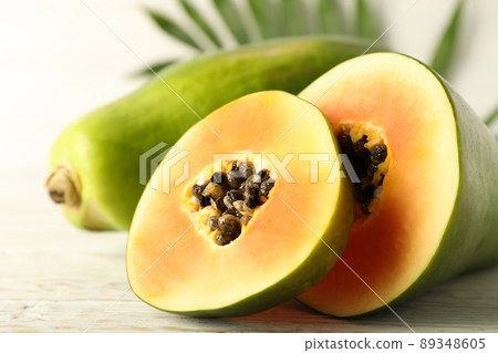 Ripe papaya with leaves on white wooden table 89348605