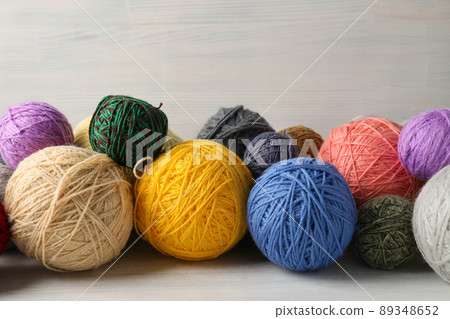 Balls of yarn on white wooden background 89348652