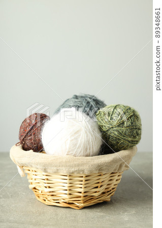 Wicker basket with yarn balls on light gray table Wicker basket with yarn balls on light gray table 89348661