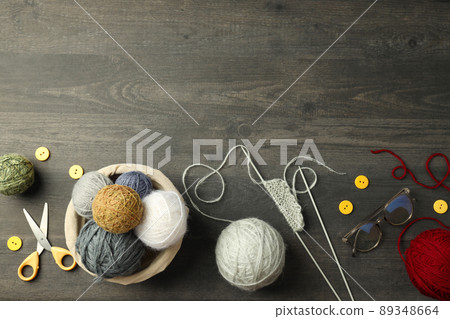 Concept of knitting with yarn balls on gray wooden table Concept of knitting with yarn balls on gray wooden table 89348664