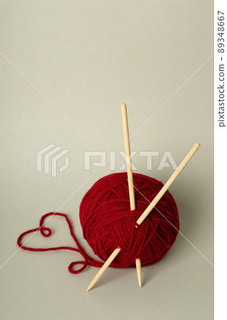 Ball of yarn with knitting needles on light gray background 89348667