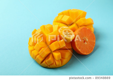 Ripe mango and orange on blue background Ripe mango and orange on blue background 89348669