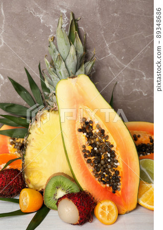 Ripe exotic fruits against gray textured background 89348686