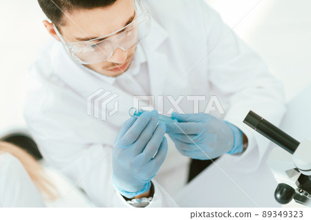 Confident young male scientist holding test tube 89349323