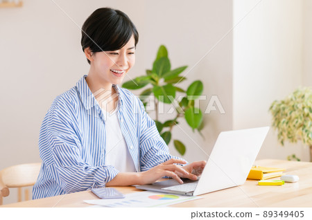 一名年輕女子在客廳里遠程辦公 89349405