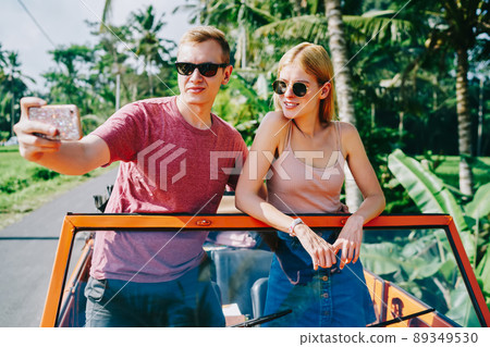 Couple taking selfie while traveling in car Couple taking selfie while traveling in car 89349530