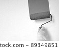 Male hand painting wall with roller. Renovating with white color paint 89349851