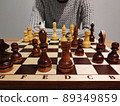 Man analyzing chess game on chess board - strategic concept. 89349859
