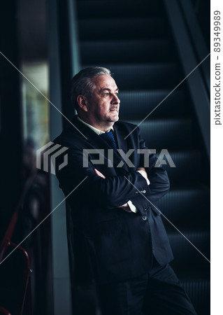 successful businessman standing on the stairs of a modern office on a dark background successful businessman standing on the stairs of a modern office on a dark background 89349989