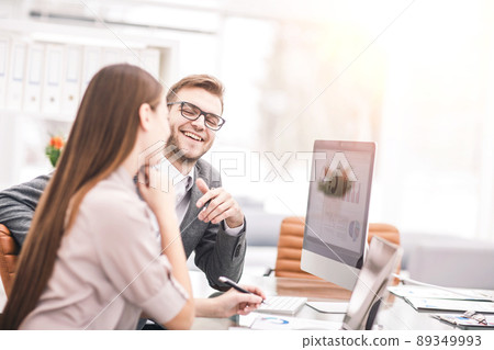 Manager and accountant are sitting and discussing financial charts with the profits of the company in the workplace Manager and accountant are sitting and discussing financial charts with the profits of the company in the workplace 89349993