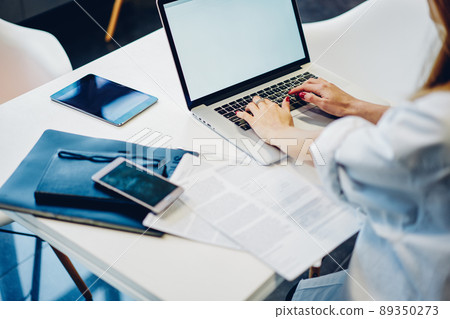 Woman using laptop for work in office 89350273