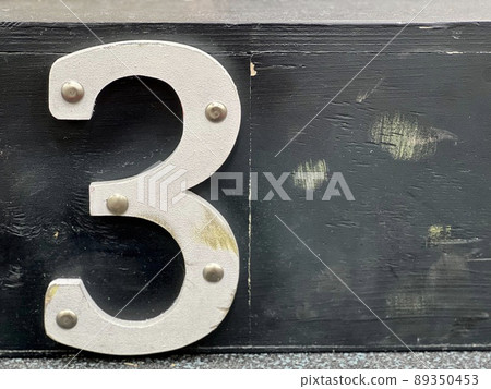 White wooden number three with nail heads on black background, copy space for your text. White wooden number three with nail heads on black background, copy space for your text. 89350453