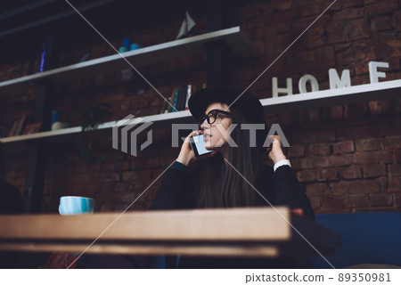 Thoughtful woman talking on mobile phone 89350981