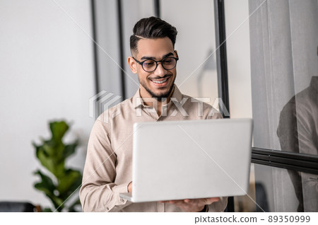 A young good-looking businessman working on a laptop 89350999