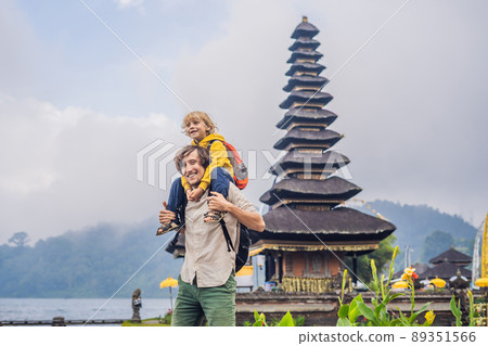 Dad and son in the background of Pura Ulun Danu Bratan, Bali. Hindu temple surrounded by flowers on Bratan lake, Bali. Major Shivaite water temple in Bali, Indonesia. Hindu temple. Traveling with Dad and son in the background of Pura Ulun Danu Bratan, Bali. Hindu temple surrounded by flowers on Bratan lake, Bali. Major Shivaite water temple in Bali, Indonesia. Hindu temple. Traveling with 89351566