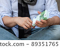 A pack of bills of one hundred euros in a man's hand 89351765