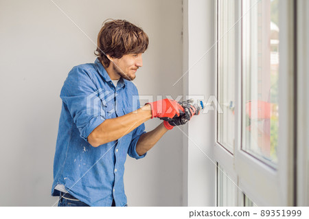Man in a blue shirt does window installation 89351999