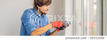 Man in a blue shirt does window installation BANNER, LONG FORMAT 89352000
