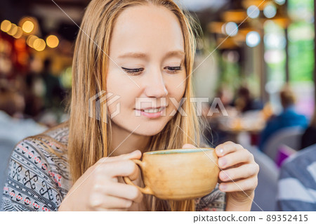 Young woman drinking Homemade Indian Sweet masala tea. Spices - cardamom, cinnamon, ginger 89352415