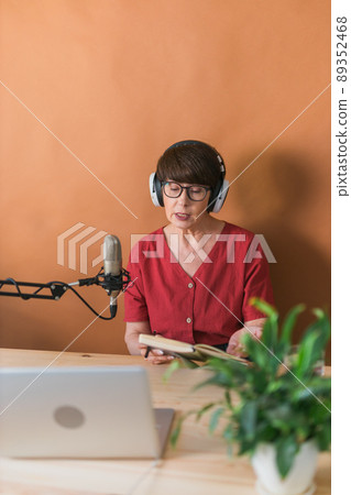 Middle-aged woman radio host making podcast recording for online show - broadcast and dj concept Middle-aged woman radio host making podcast recording for online show - broadcast and dj concept 89352468