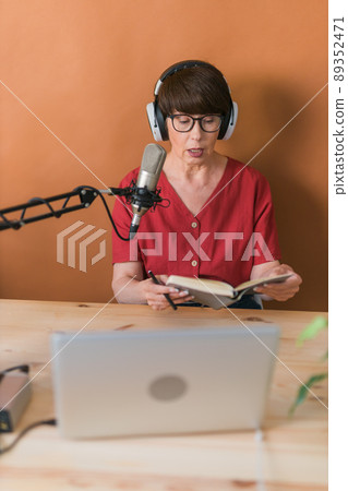 Middle-aged woman radio host making podcast recording for online show - broadcast and dj concept 89352471