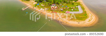 Strong men floating on a SUP boards in a beautiful bay on a sunny day. Aerial view of the men crosses the bay using the paddleboard. Water sports, competitions 89352690