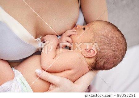 Young mother breastfeeding her newborn baby at home 89353251