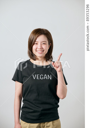 一位穿著純素 T 卹並用食指指著的年輕女子 89353296